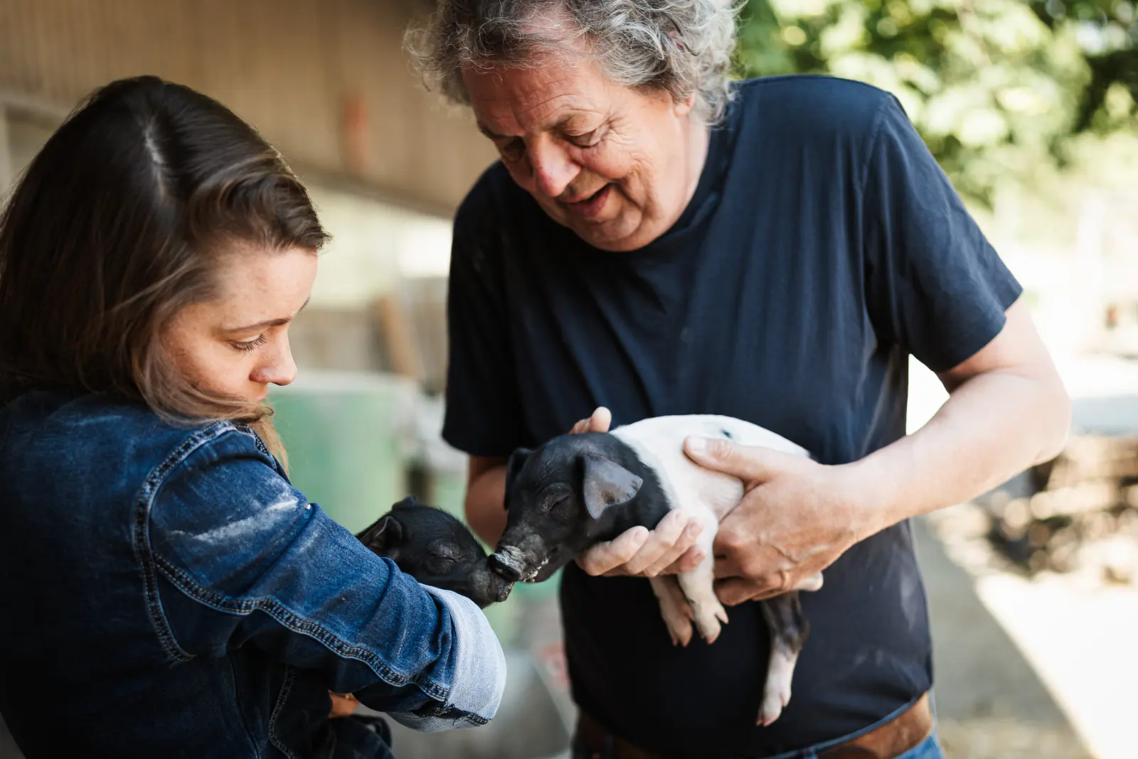 Rebecca Gischel und Karl Schweisfurth mit einem Ferkel auf dem Arm