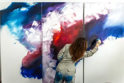 Rebecca Gischel besprüht eine großformatige Leinwand